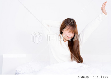 Young Asian woman stretching in bed after wake up 68301455