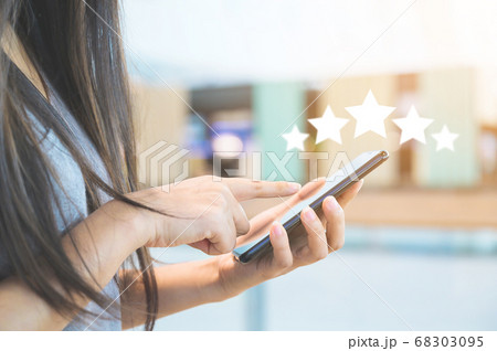 Close-up image of woman hand using mobile smart phone with icon five star Close-up image of woman hand using mobile smart phone with icon five star 68303095