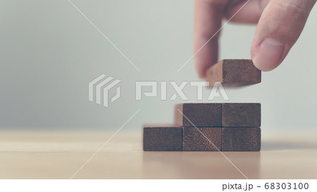Hand arranging wood block stacking as step stair. Hand arranging wood block stacking as step stair. 68303100