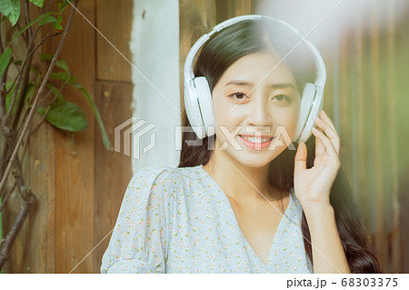 the woman is listening to music 68303375