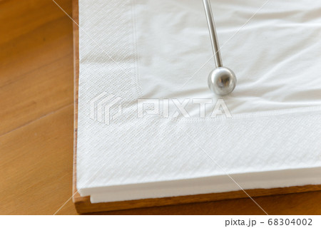 Metal paperweight on stack of white square paper napkin. modern paper napkin holder 68304002