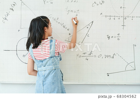 Schoolgirl writing on whiteboard 68304562