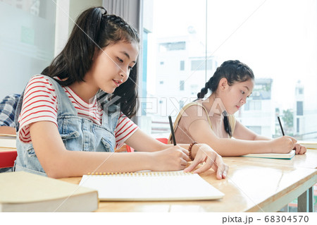 Students writing in copybooks 68304570