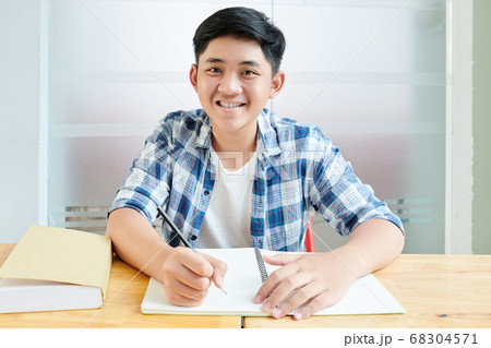 Schoolboy writing in copybook 68304571