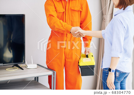 Housewife and repairman shaking hands 68304770