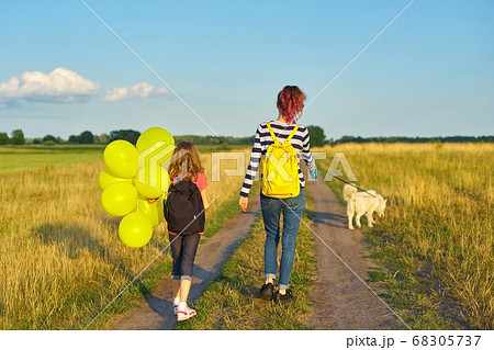 Children two girls walking along country road with dog and balloon, back view 68305737