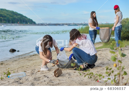 Group of students with teacher in nature doing cleaning of plastic garbage 68306037