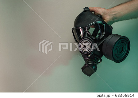 Hand hold black old gas mask in the color light. 68306914