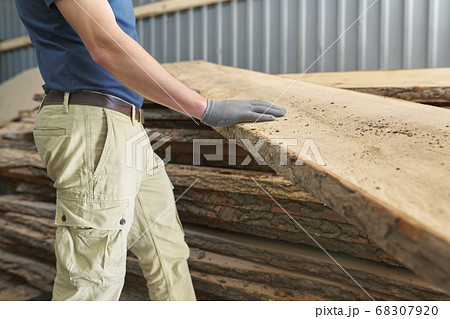 Carpenters hands with plank wood at carpentry woodworking workshop 68307920