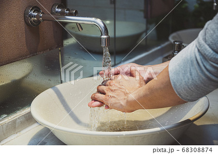 Closeup hands washing with Chrome faucet and water for Coronavirus pandemic prevention in bathroom, self responsibility cleaning, hand hygiene corona virus protection concept 68308874