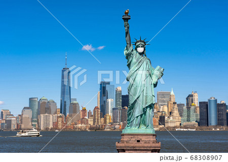 The Statue of Liberty wearing surgical mask when Covid-19 Outbreak over the Scene of New york cityscape river side, united state, coronavirus pandemic, Architecture and building with tourist concept 68308907