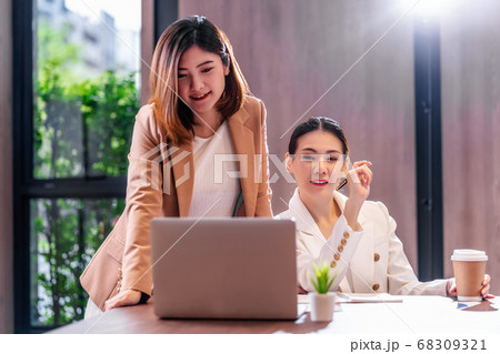 Two asian businesswomen working with the partner business via technology laptop in modern meeting room, office or working space, coffee break, partner and colleague concept. Two asian businesswomen working with the partner business via technology laptop in modern meeting room, office or working space, coffee break, partner and colleague concept. 68309321