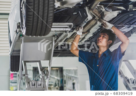 Asian mechanic repairing and light up under the car in maintainance service center which is a part of showroom, technician or engineer professional work for customer, car repair and maintain concet Asian mechanic repairing and light up under the car in maintainance service center which is a part of showroom, technician or engineer professional work for customer, car repair and maintain concet 68309419