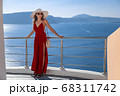 young woman enjoying view of Santorini, Greece 68311742