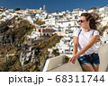 Happy smiling woman tourist traveling on luxury cruise in Mediterranean, Greece, Santorini. Background architecture island sea sky 68311744