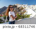 Happy smiling woman tourist traveling on luxury cruise in Mediterranean, Greece, Santorini. Female with folded arms, background architecture island sea sky 68311746
