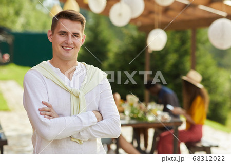 Smiling Young Man Posing at Outdoor Summer Party Smiling Young Man Posing at Outdoor Summer Party 68312022