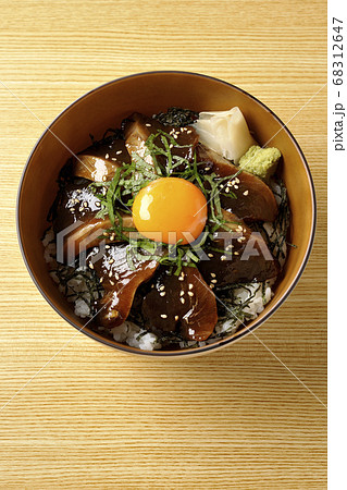 刻んだ海苔や大葉 ガリやワサビそして卵黄が中央に乗った鰹の漬け丼 俯瞰 の写真素材