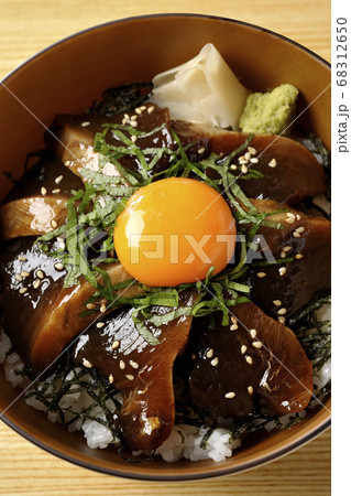 刻んだ海苔や大葉 ガリやワサビそして卵黄が中央に乗った鰹の漬け丼 俯瞰 の写真素材