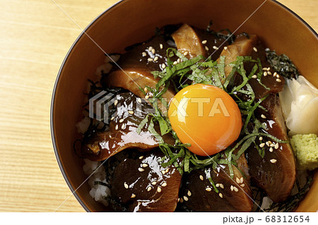 刻んだ海苔や大葉 ガリやワサビそして卵黄が中央に乗った鰹の漬け丼 俯瞰 の写真素材