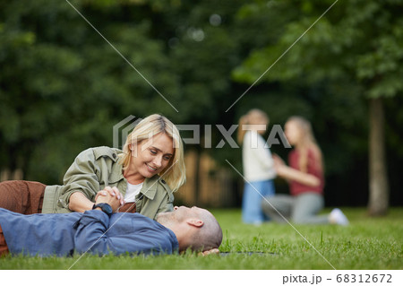 Adult Couple Lying on Green Grass in Park 68312672
