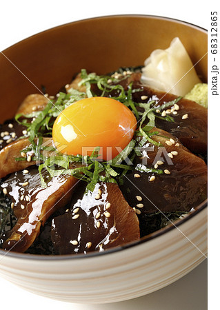 刻んだ海苔や大葉、ガリやワサビそして卵黄が中央に乗った鰹の漬け丼(白背景) 68312865