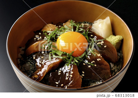 刻んだ海苔や大葉、ガリやワサビそして卵黄が中央に乗った鰹の漬け丼(黒背景) 68313018