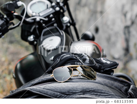 sunglasses and gloves on the background of a motorcycle fuel tank sunglasses and gloves on the background of a motorcycle fuel tank 68313595