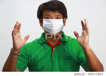 Masked Asian man prevent germs and wear green shirt. Masked Asian man prevent germs and wear green shirt. 68313661