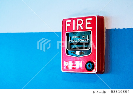 Red button handbrake fire alarm on the wall. 68316364