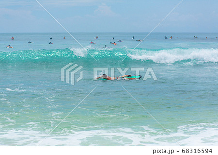 The guy is swimming on the surf board on the 68316594
