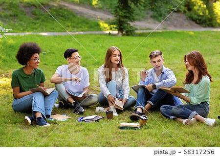 Students Leisure. Group of multiethnic college friends studying together outdoors at campus 68317256