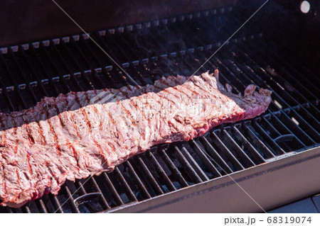 Beef steak on the grill, barbecue bavette in the garden close up, grilled beef outdoors in the summer Beef steak on the grill, barbecue bavette in the garden close up, grilled beef outdoors in the summer 68319074