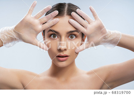 Beautiful young woman wearing transparent disposable gloves Beautiful young woman wearing transparent disposable gloves 68319700