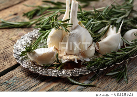 Rosemary and garlic on a wooden table. 68319923