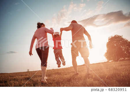 girl with mother and father holding hands on the nature girl with mother and father holding hands on the nature 68320951