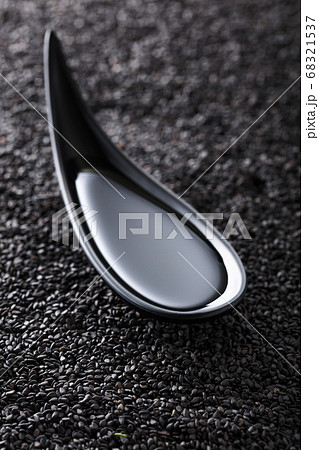 Sesame oil in small bowl on a background of black Sesame oil in small bowl on a background of black 68321537