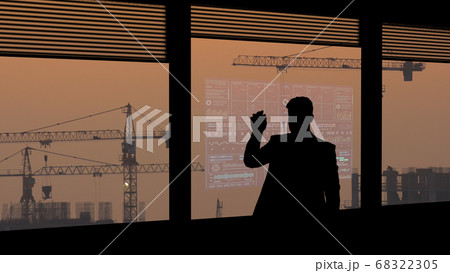 The The businessman working on a virtual screen on the wind turbines background working on a virtual screen on the night cityscape background 68322305