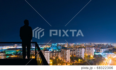 The The businessman working on a virtual screen on the wind turbines background working on a virtual screen on the night cityscape background 68322306