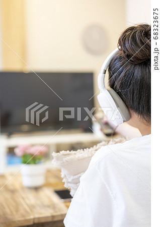 リビングで寛いで、ヘッドフォンをしてドラマをみる 68323675