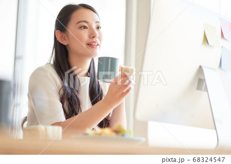 PCを見ながらランチを食べる女性 PCを見ながらランチを食べる女性 68324547