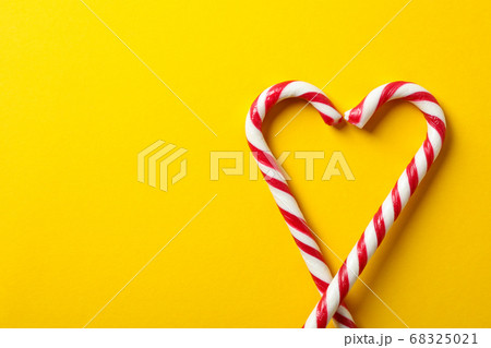 Sweet candy canes on yellow background, space for Sweet candy canes on yellow background, space for 68325021