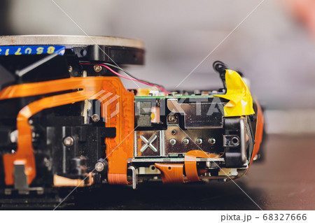 Engineer and technician Minitures are fixing camera mirror box assembly , Miniture workers are checking optics and carry out maintenance and cleaning of the broken camera at the service center. 68327666