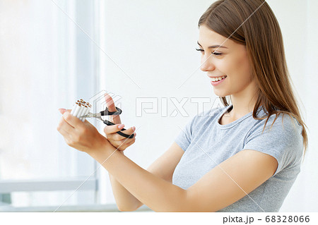 Stop smoking, young woman cuts a cigarette with scissors 68328066