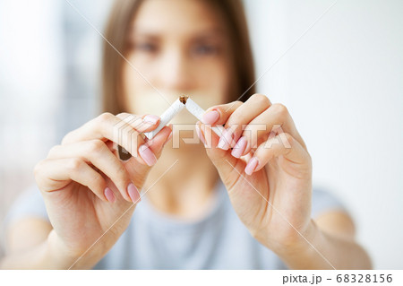 Stop smoking, young girl holding broken cigarette in hands. Stop smoking, young girl holding broken cigarette in hands. 68328156