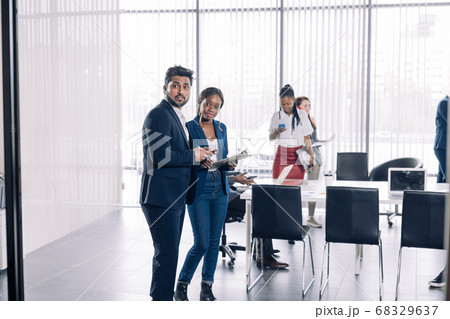 Diverse smiling businesspeople having conversation standing together at meeting. Diverse smiling businesspeople having conversation standing together at meeting. 68329637