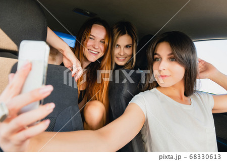 Three girls make selfie at car salon Three girls make selfie at car salon 68330613