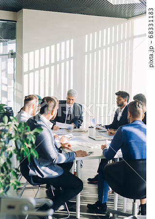 Multiracial male business executives discuss project sitting at conference table Multiracial male business executives discuss project sitting at conference table 68331183