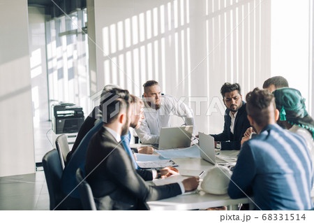 Optimistic businessman in white shirt collaborating with his team at meeting Optimistic businessman in white shirt collaborating with his team at meeting 68331514
