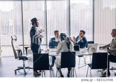 Serious Indian CEO in interacting with multiracial vendors at corporate meeting Serious Indian CEO in interacting with multiracial vendors at corporate meeting 68332406